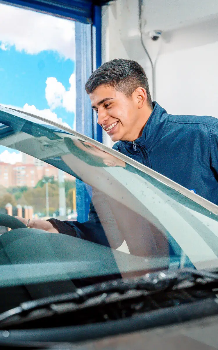 Vendedor da Autoglass ajudando cliente em loja durante o dia, ambiente com clima amigável, focado em atendimento de qualidade.
